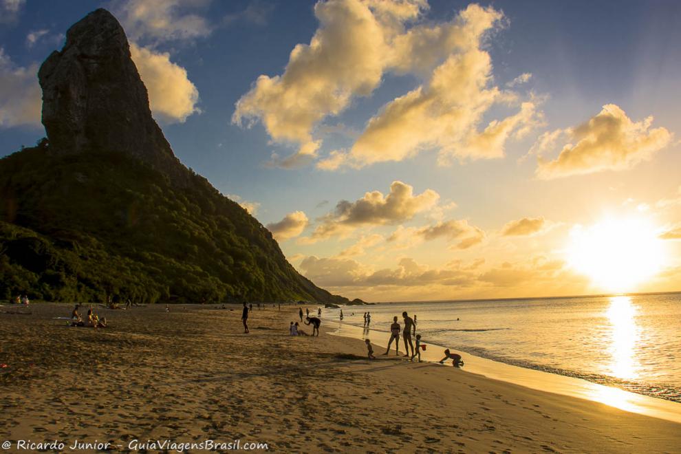 Imagem de turistas em um belo entardecer nas areias da Praia da Conceição.